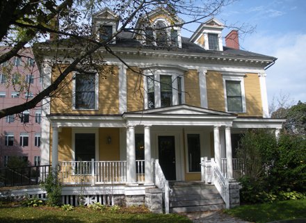 two story yellow colonial house with columns and porch