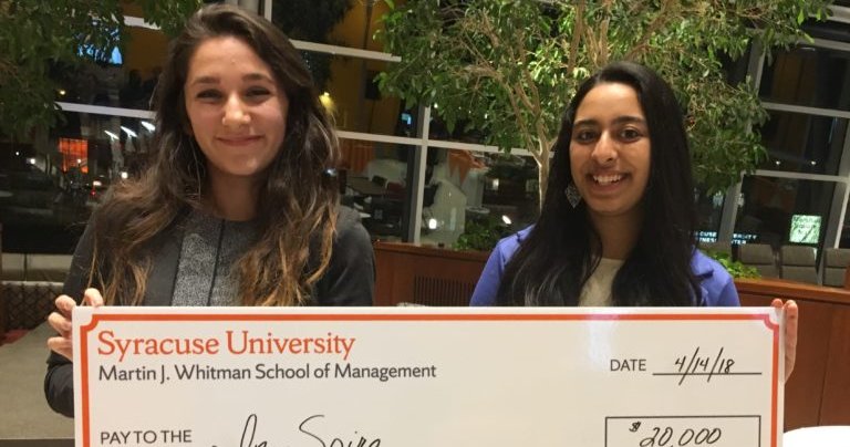two women holding an oversized check