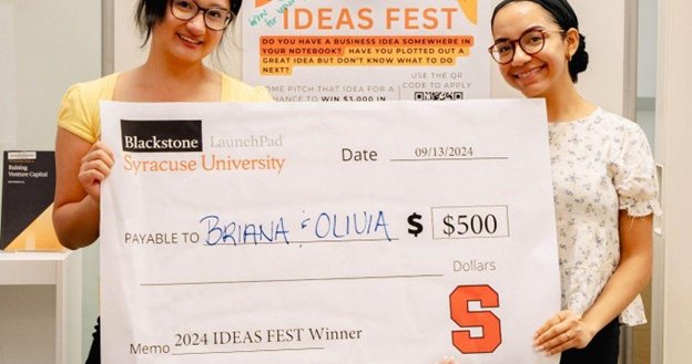 two people holding up giant check
