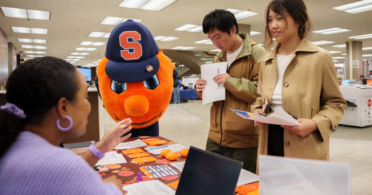 otto and students stop at a table during welcome fest