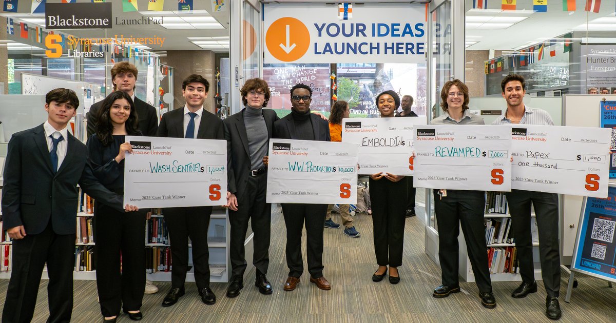 students posing with giant checks