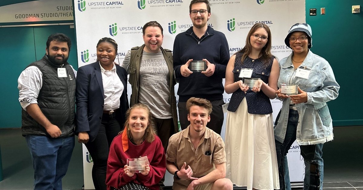 8 people posing, some with awards in hand
