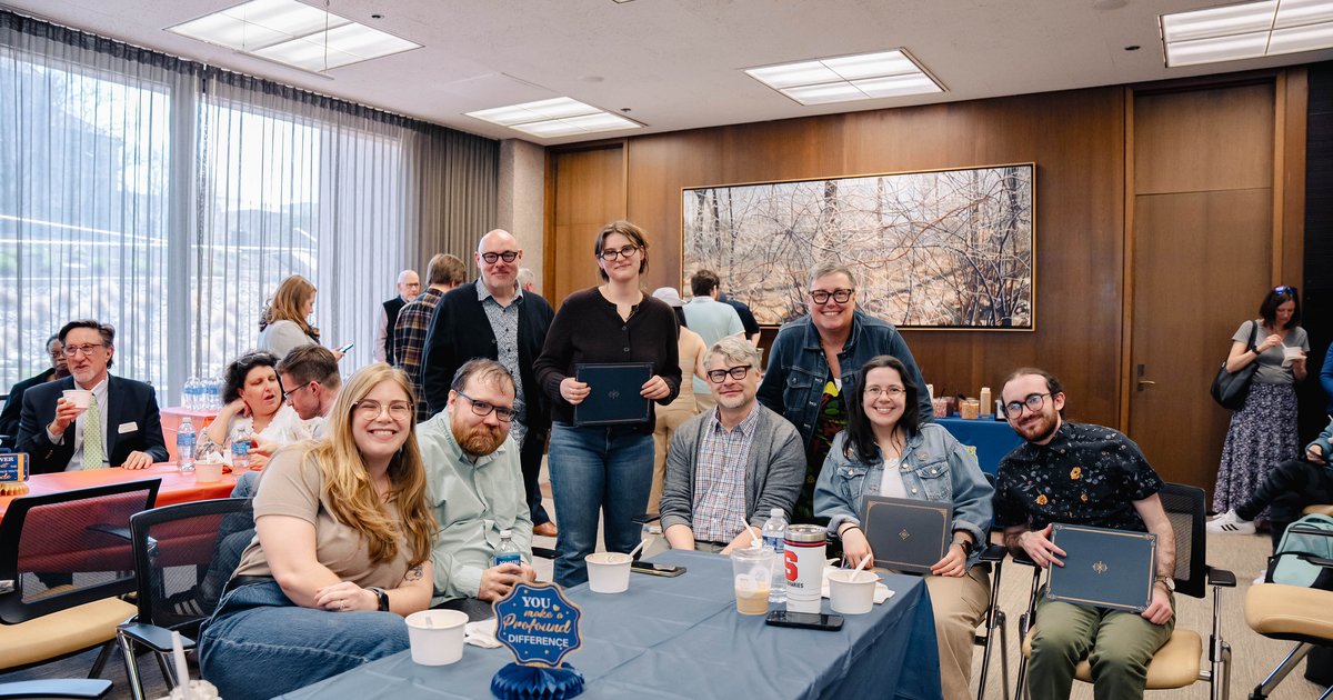 group of people sitting and standing around table