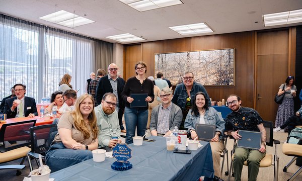 group of people sitting and standing around table