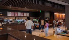 A hallway in the middle, cafe on the right side, and people sitting on the left side