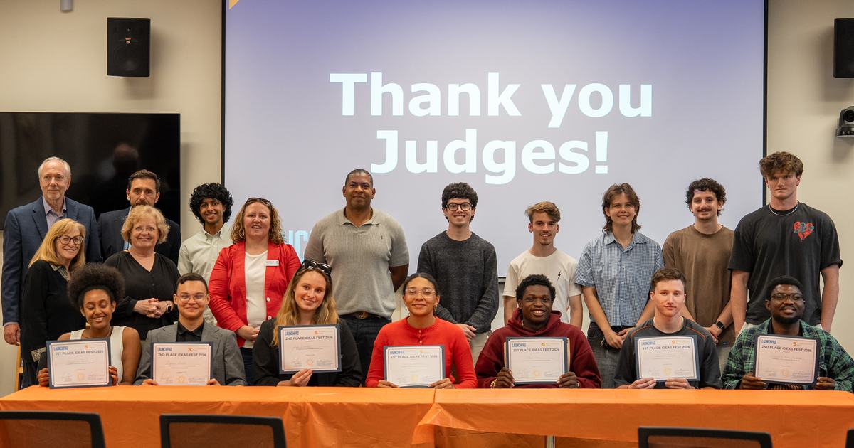 group of people posing for photos with screen behind that reads "Thank you judges"