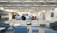 room with water wall, white sofas, computer workstations and digital sign on wall