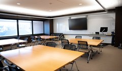 classroom with large monitor in front, u-shaped tables and chairs around room