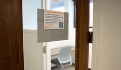 A private room with desk and chair and a glass window