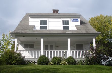 white colonial with porch across entire first floor