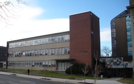 brick and glass three story building with section on right that is taller and made of brick