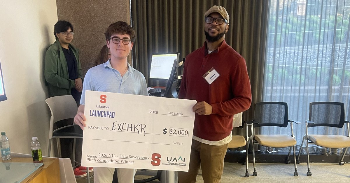 two people posing with giant check