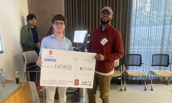 two people posing with giant check