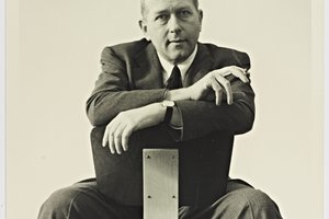 black and white of marcel breuer sitting on a chair