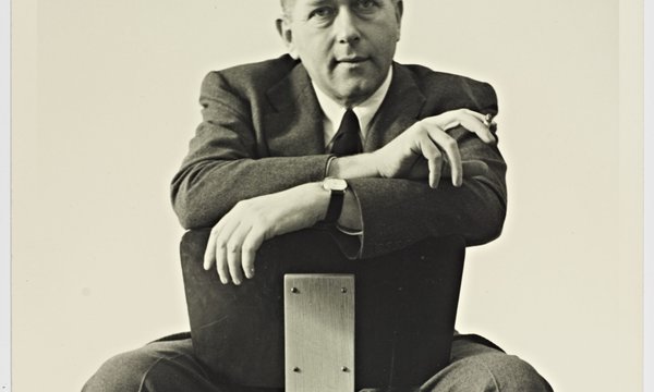 black and white of marcel breuer sitting on a chair