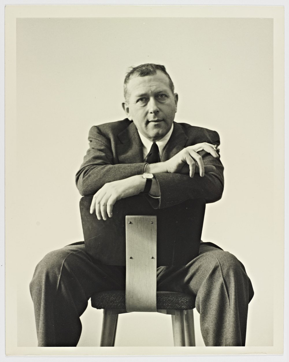 black and white of marcel breuer sitting on a chair