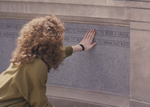 A student touches the names engraved on the Place of Remembrance at the 22 April 1990 dedication ceremony. Place of Remembrance Collection.