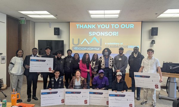 numerous students holding oversized checks