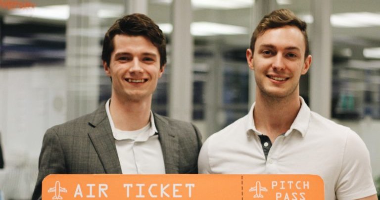Quinn King and Alec Gillinder holding an air ticket