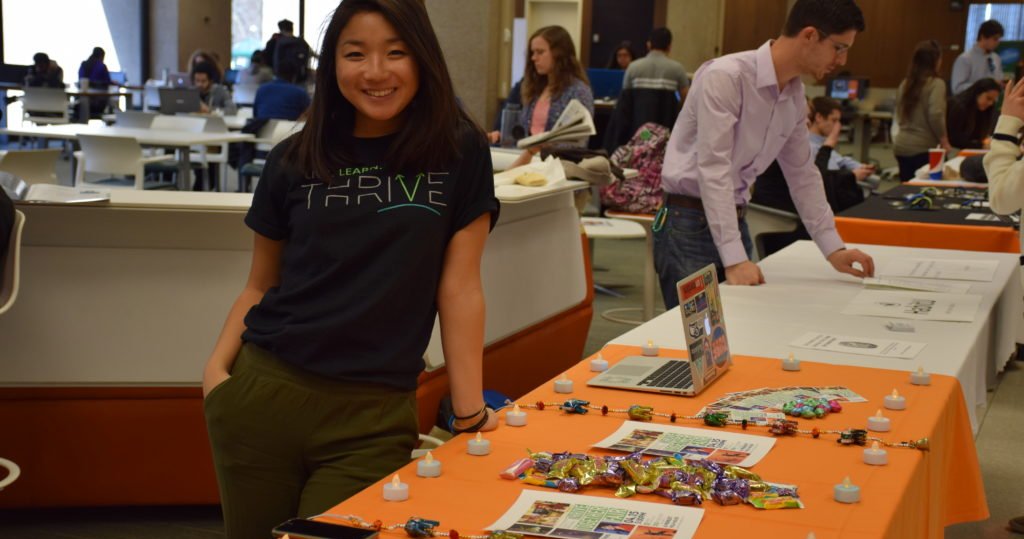 Amanda Chou stands next to a table