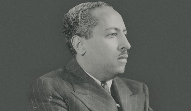 Black and white portrait of Arna Bontemps in profile wearing a pinstripe suit jacket with a mustache and short hair