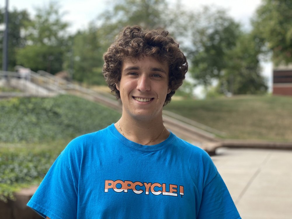 student in a blue POPCYCLE brand shirt