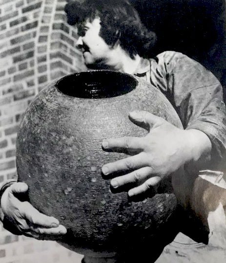 Black and white photograph of Maija Grotell, holding a large, round vase, 1941. Maija Grotell Papers.