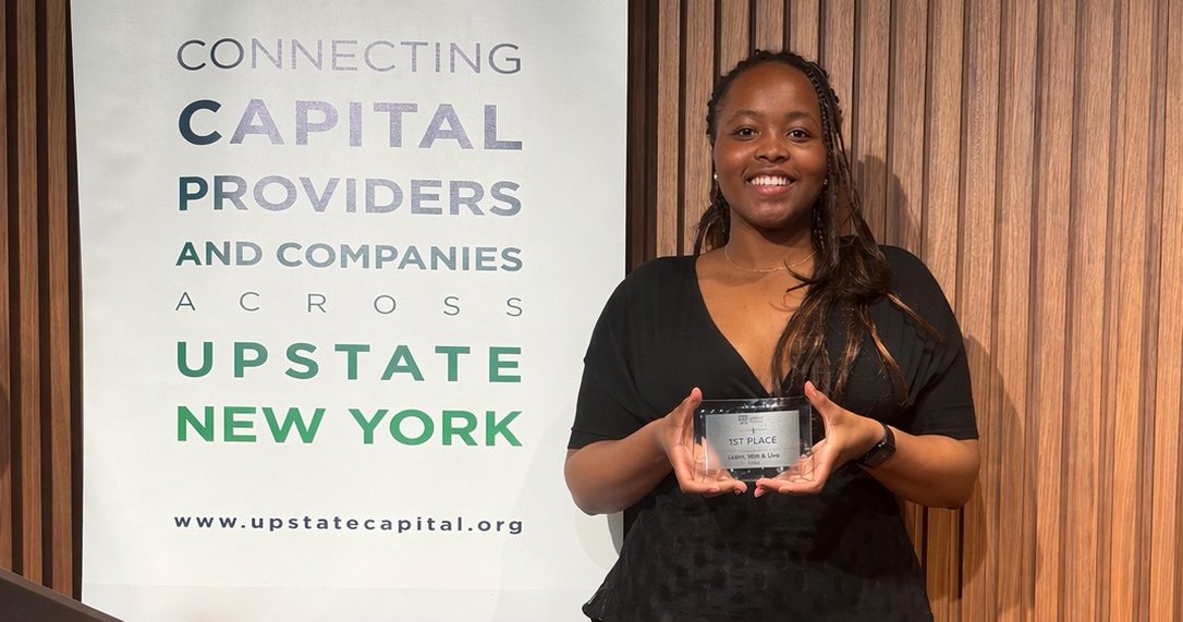 person holding award next to banner