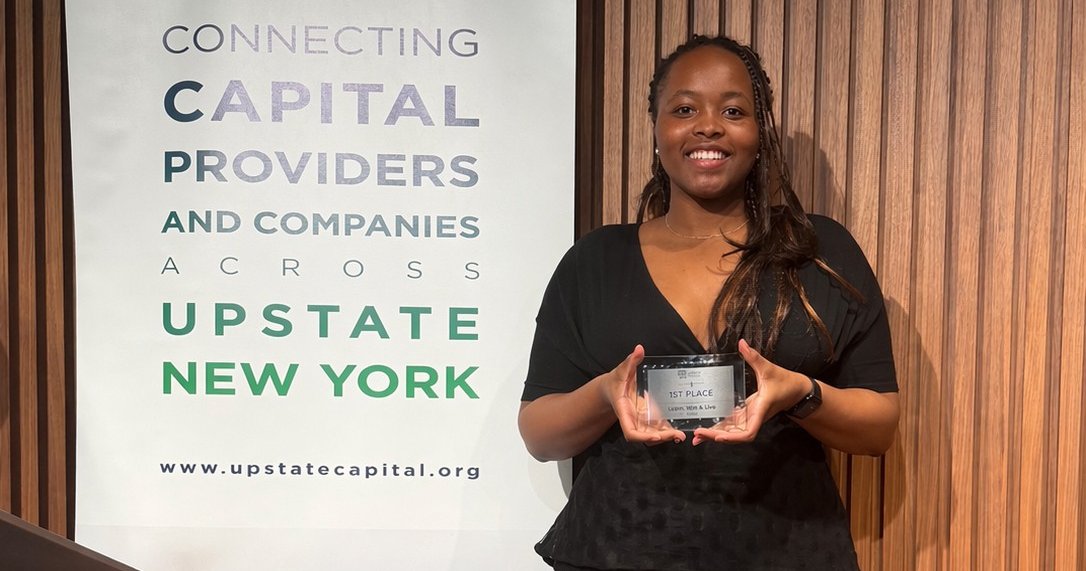 person holding award next to banner