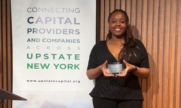 person holding award next to banner
