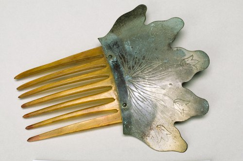 Combs were occasionally made of multiple materials (horn and metal in this case) as a way to add to their decorative appeal.