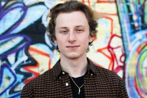 young man against a bright graffiti wall