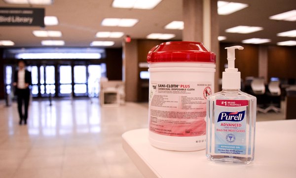 Hand sanitizer and disinfectant wipes on white counter in Bird Library