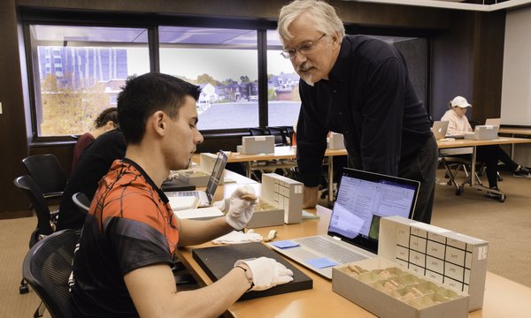 Prof. James Watts working with student in Special Collections
