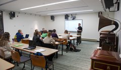 teacher instructing in front of students seated in classroom