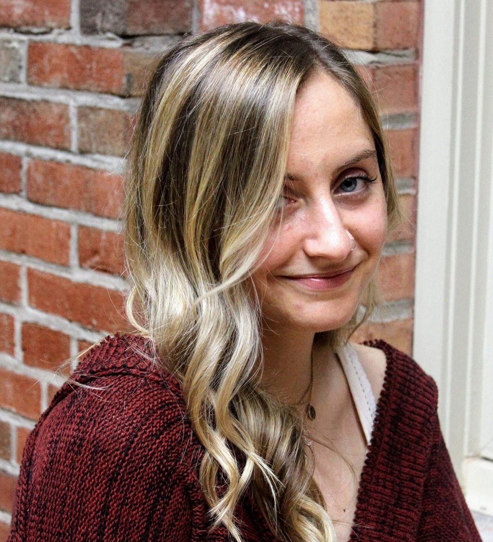 young woman in front of a brick wall