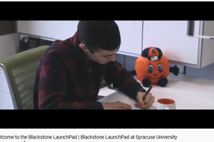 student writing on his notebook