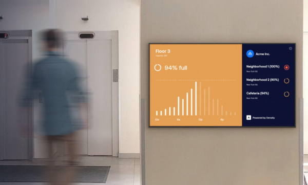 person walking next to a wall monitor