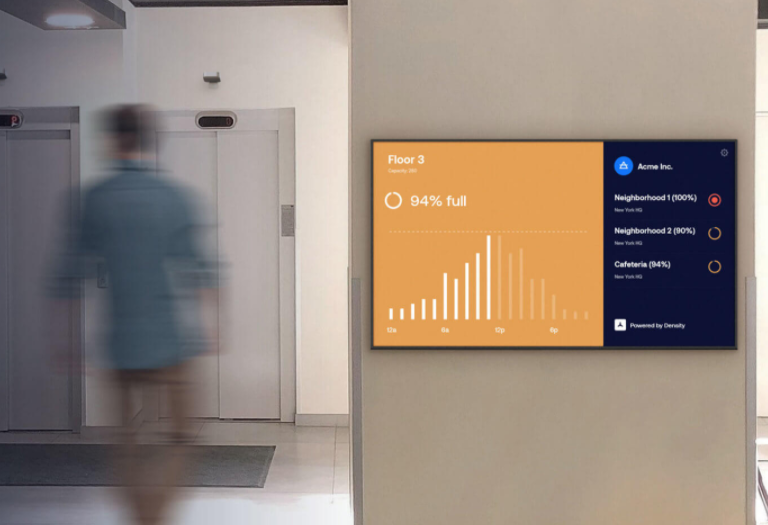 person walking next to a wall monitor