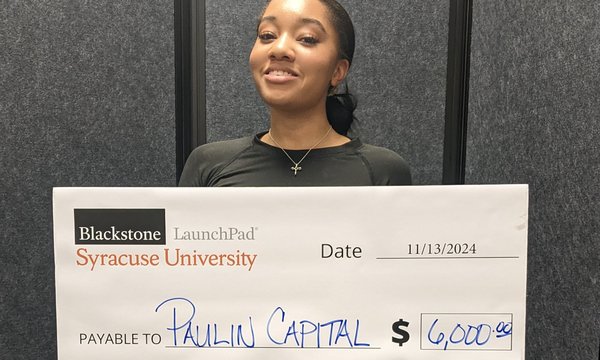 person holding giant check for Paulin Capital $6,000