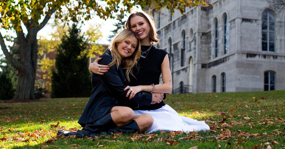 Emma Lueders and Jennie Bull hug for a photo in front of Hall of Languages