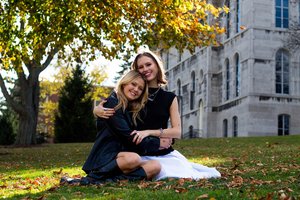 Emma Lueders and Jennie Bull hug for a photo in front of Hall of Languages