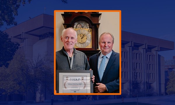 two people standing holding certificate in front of grandfather clock