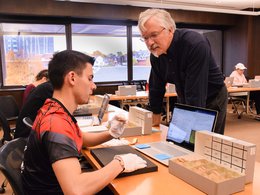 Professor Jim Watts helping a student examine cuneiform tablets in Special Collections