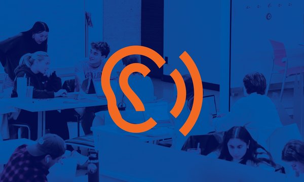 man in suit amid group of students eating donuts