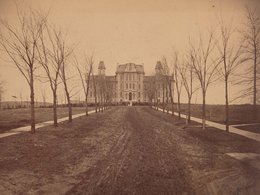 Sepia toned photo of the Hall of Languages, dated circa 1880, with bare trees and empty grass surrounding walkways
