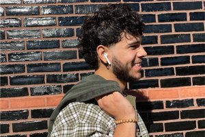 Gabriel Davila-Campos smiling, looking to the right side, while holding a sweater over his shoulder