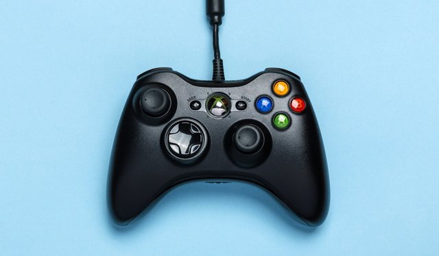 Wired black Xbox controller on a light blue background