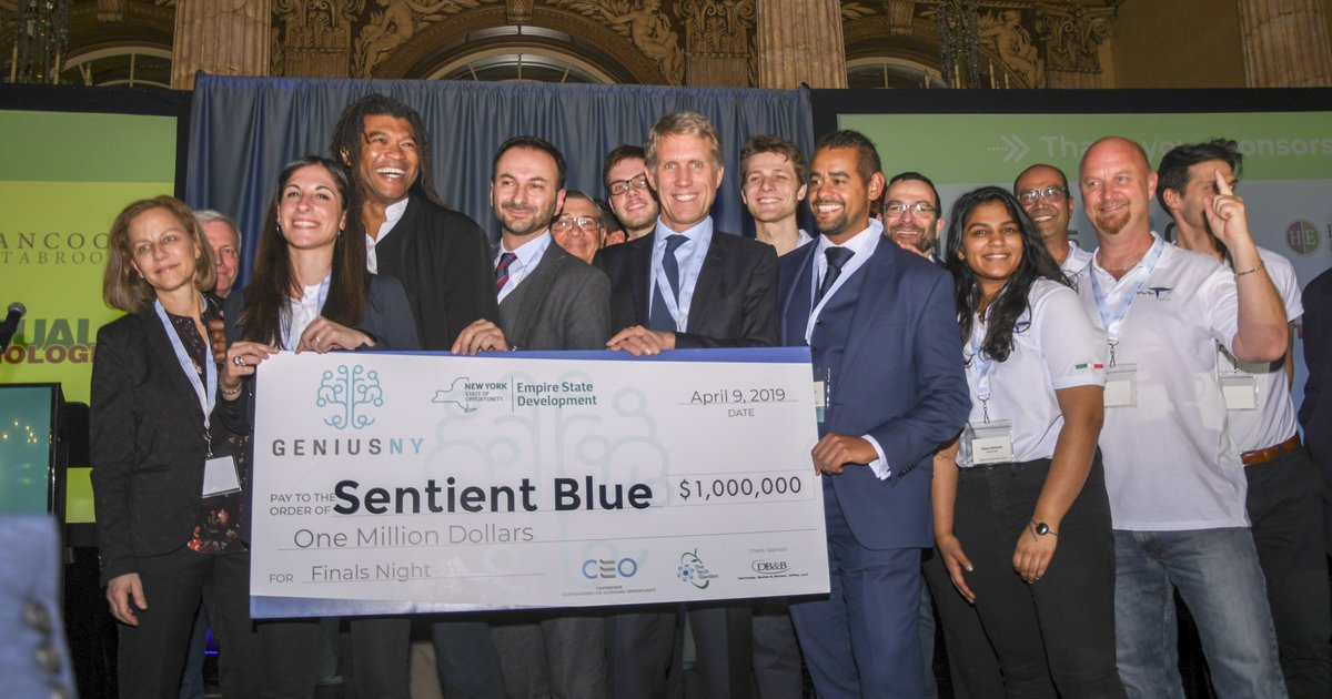 group holding giant check for Sentient Blue