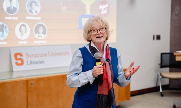 woman holding microphone with digital screen behind her